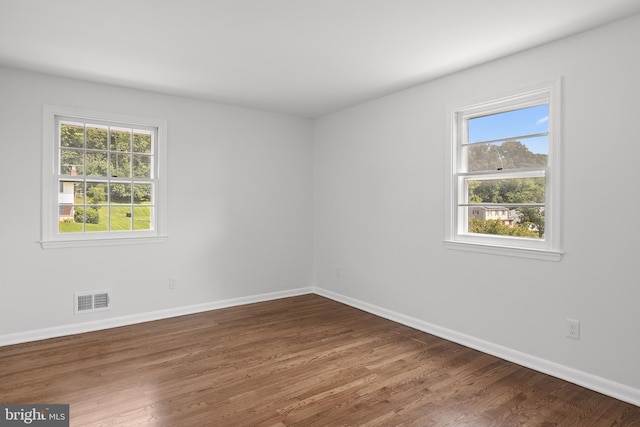 spare room with hardwood / wood-style flooring and a healthy amount of sunlight