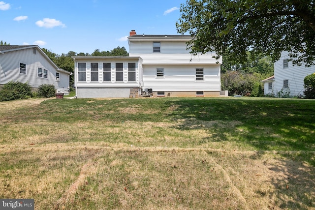 back of property featuring a lawn