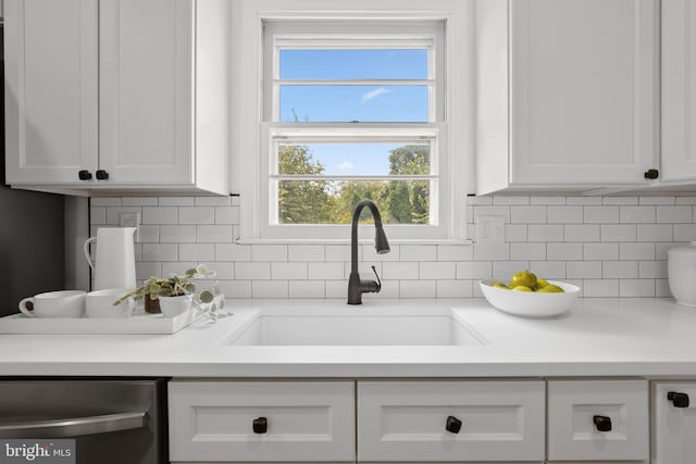 interior details with white cabinets, decorative backsplash, dishwasher, and sink