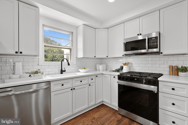 kitchen with sink, white cabinets, stainless steel appliances, and dark hardwood / wood-style floors