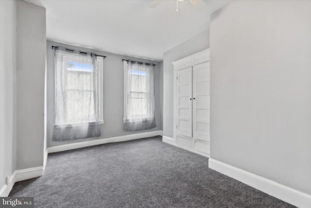 carpeted spare room featuring ceiling fan