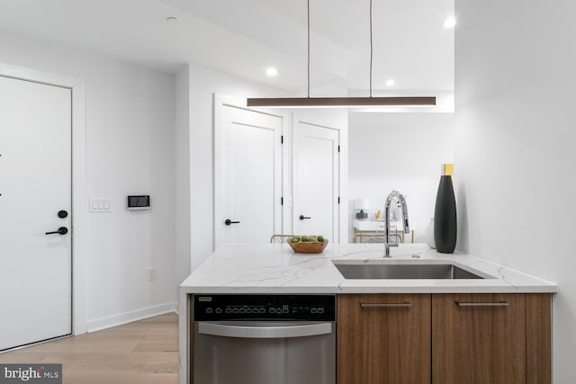 kitchen with sink, stainless steel dishwasher, and light wood-type flooring