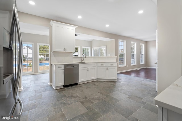 kitchen with white cabinets, sink, stainless steel appliances, and tasteful backsplash