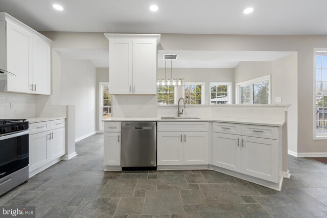 kitchen with appliances with stainless steel finishes, white cabinetry, and sink