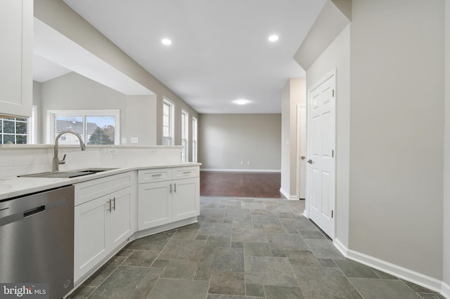 kitchen with dishwasher, backsplash, white cabinets, and sink