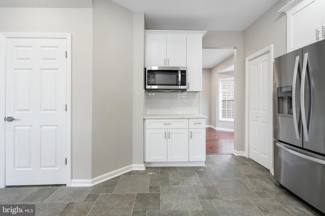 kitchen featuring white cabinetry, backsplash, and appliances with stainless steel finishes