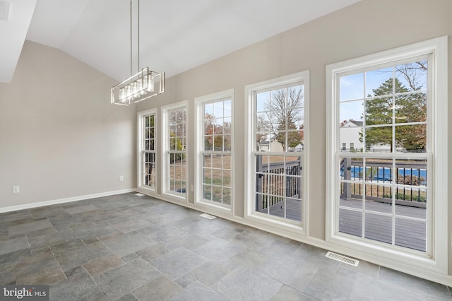 unfurnished dining area with a notable chandelier and vaulted ceiling