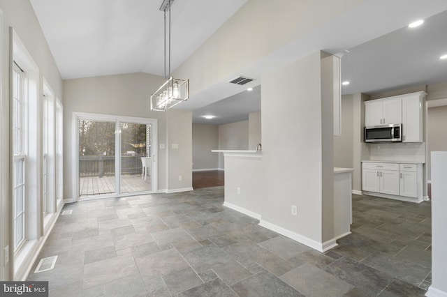 unfurnished dining area with vaulted ceiling