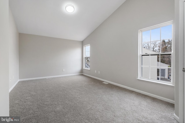 carpeted empty room featuring high vaulted ceiling