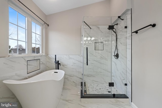 bathroom featuring tile walls and independent shower and bath