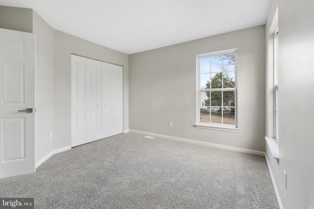 unfurnished bedroom featuring carpet and a closet