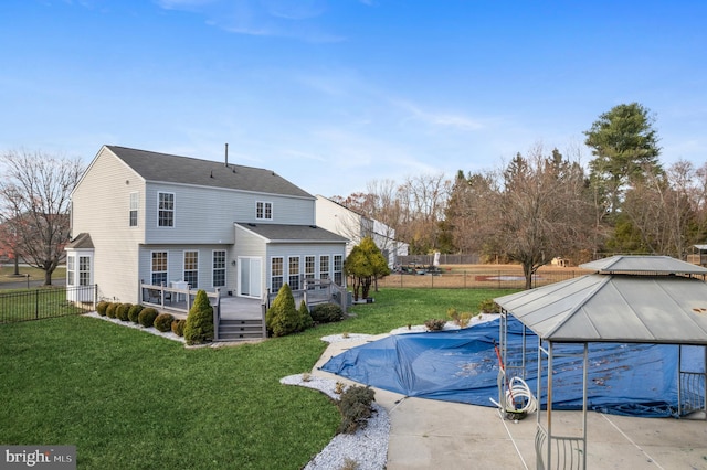 rear view of property with a lawn and a pool side deck