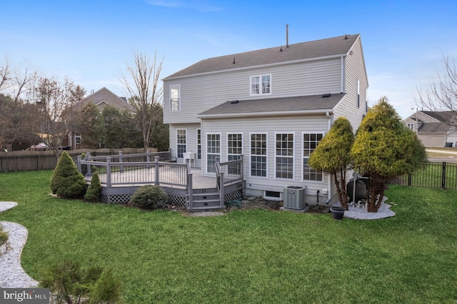 rear view of property with a deck, a yard, and central AC