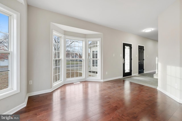 interior space with a wealth of natural light and dark wood-type flooring