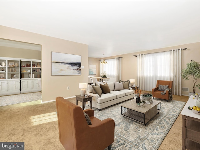 carpeted living room featuring a chandelier