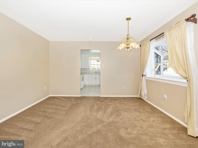 unfurnished room with light carpet, sink, and an inviting chandelier