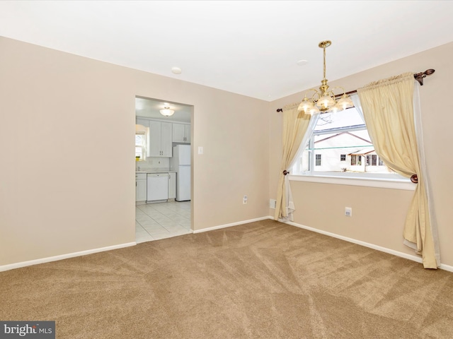 empty room featuring light carpet and an inviting chandelier