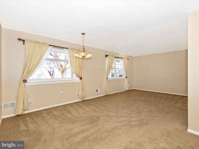 unfurnished room with carpet flooring and a notable chandelier