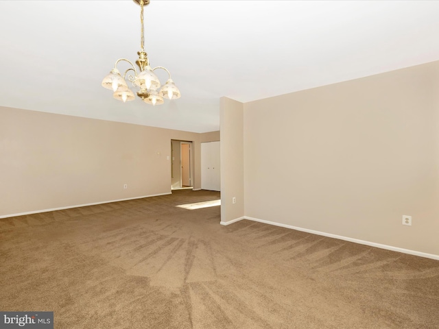 unfurnished room with carpet floors and an inviting chandelier