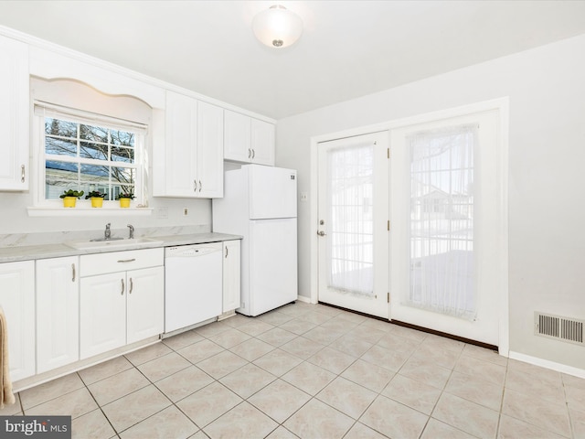 kitchen featuring sink, white cabinets, white appliances, and light tile patterned floors