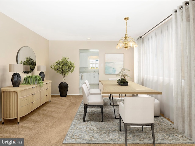 carpeted dining area featuring sink and an inviting chandelier