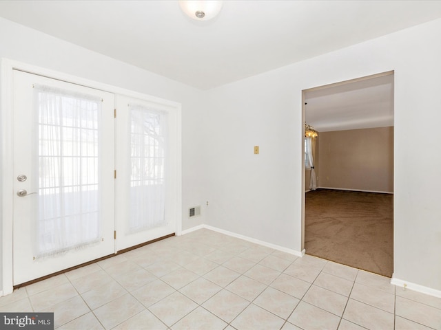 carpeted empty room with a chandelier