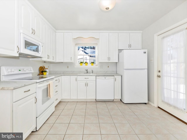 kitchen featuring light tile patterned floors, white appliances, white cabinetry, and sink