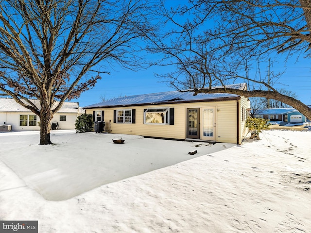 view of snow covered back of property