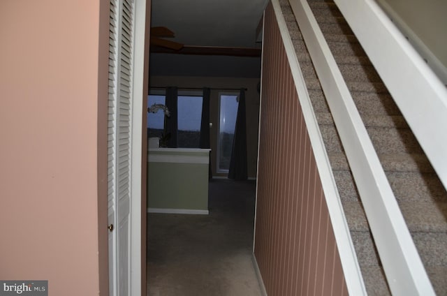 hall featuring dark colored carpet