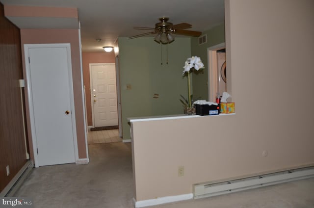 kitchen with a baseboard heating unit, light colored carpet, and ceiling fan