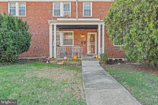 property entrance with a lawn and a porch