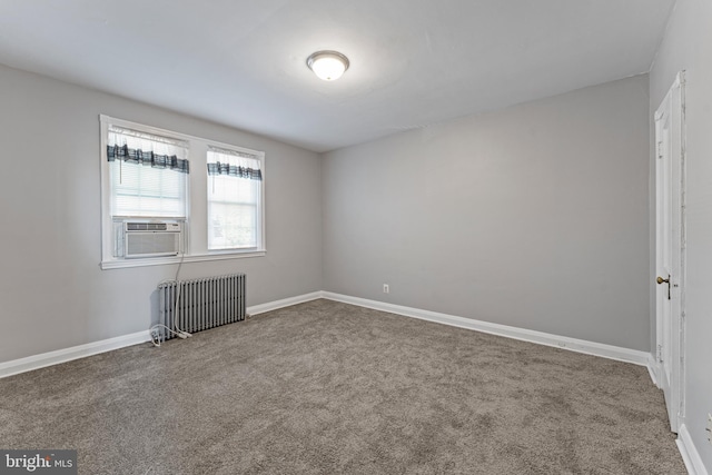 spare room featuring carpet flooring, cooling unit, and radiator heating unit