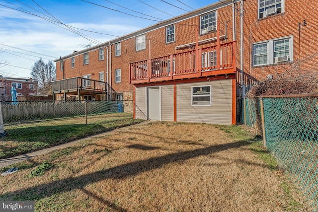 back of property featuring a wooden deck and a lawn