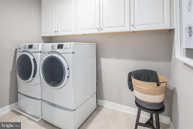 washroom featuring washing machine and clothes dryer and cabinets