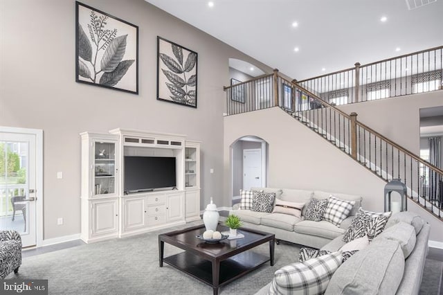 living room with carpet floors and a towering ceiling