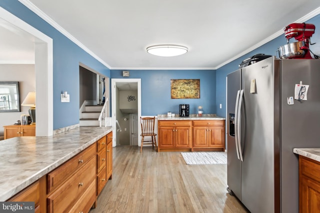 kitchen with ornamental molding, light hardwood / wood-style flooring, light stone counters, and stainless steel fridge with ice dispenser