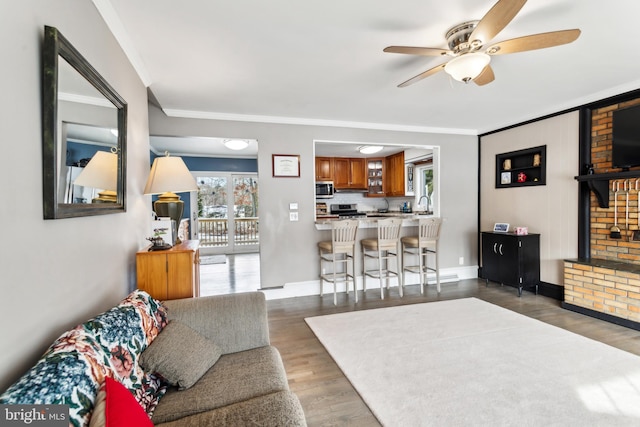 living room featuring crown molding, ceiling fan, and dark hardwood / wood-style floors