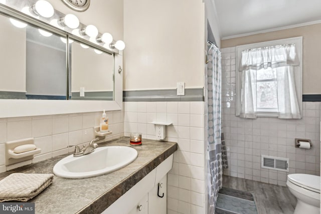 bathroom featuring toilet, tile walls, ornamental molding, vanity, and hardwood / wood-style flooring