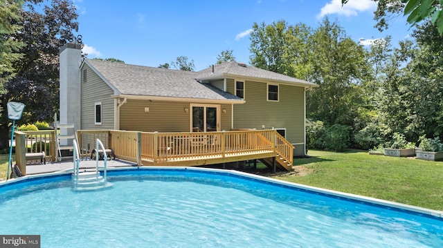 view of swimming pool featuring a yard and a deck