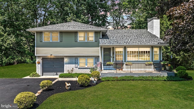 tri-level home with a garage, a front yard, and a porch