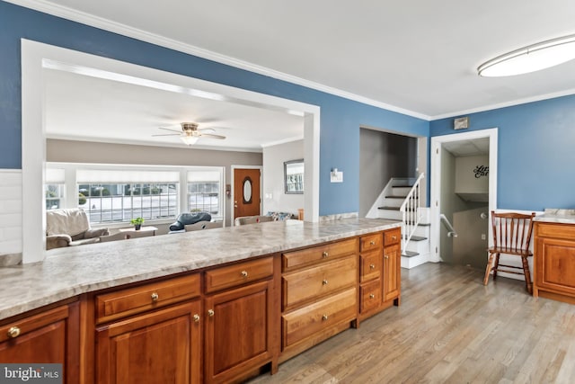 kitchen featuring crown molding, ceiling fan, light stone countertops, and light hardwood / wood-style floors