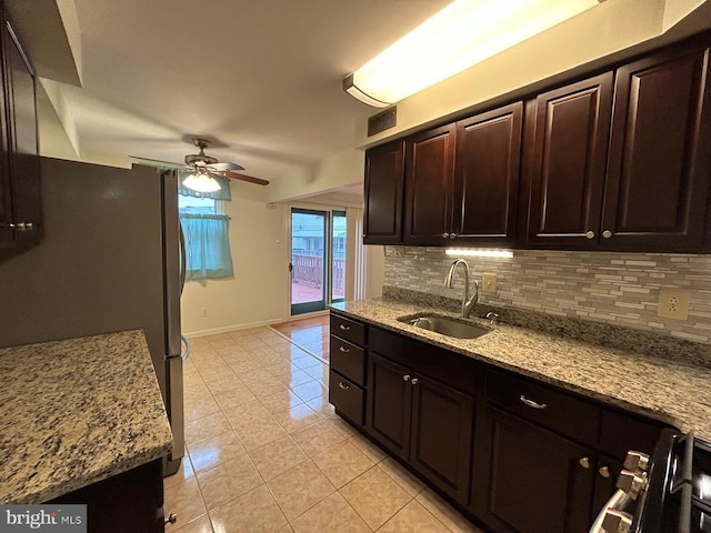 kitchen featuring decorative backsplash, light stone countertops, and sink