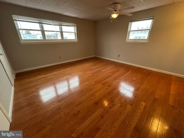 empty room featuring light wood-type flooring, plenty of natural light, and ceiling fan