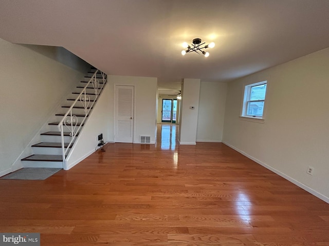 unfurnished living room with hardwood / wood-style floors, ceiling fan, and a healthy amount of sunlight