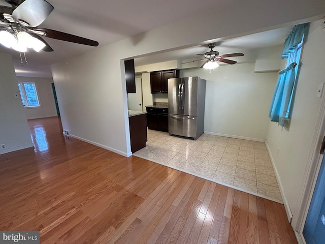 kitchen with stainless steel fridge, light hardwood / wood-style flooring, and ceiling fan