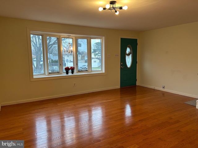 entrance foyer featuring wood-type flooring and an inviting chandelier