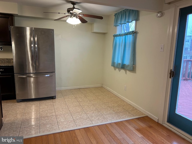 kitchen featuring stainless steel refrigerator, ceiling fan, dark brown cabinets, and light wood-type flooring