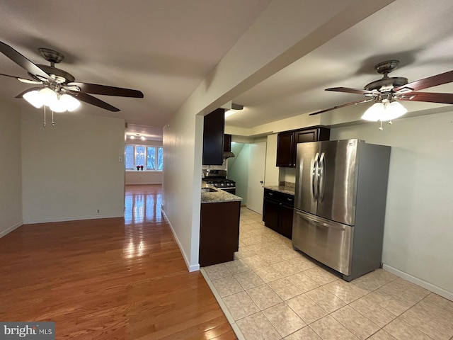 kitchen featuring ceiling fan, light stone counters, light wood-type flooring, and appliances with stainless steel finishes