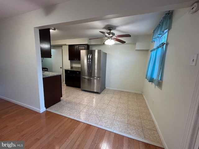 kitchen featuring stainless steel fridge, dark brown cabinets, light hardwood / wood-style floors, and ceiling fan