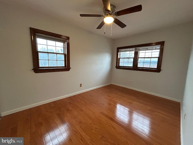 spare room with light wood-type flooring, plenty of natural light, and ceiling fan